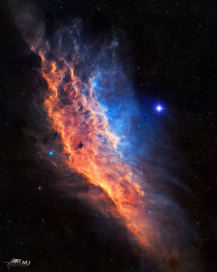 The California Nebula, a sweeping diagonal flame of orange and blue gas