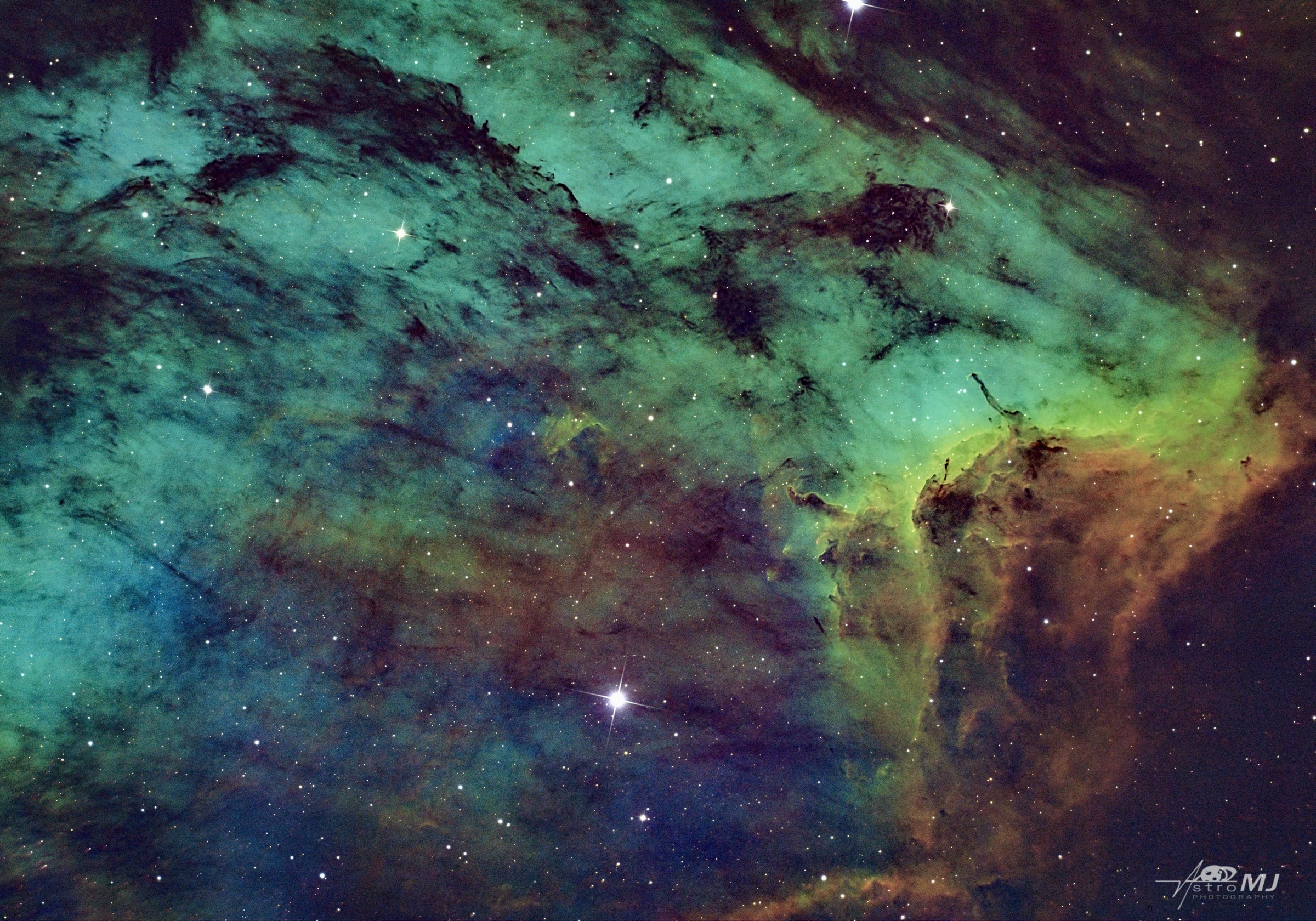 The Cygnus Wall, dramatic teal and gold dust pillars carved by radiation from newborn stars